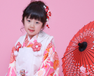 番傘を横に座る着物姿の3歳女児
