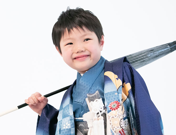 番傘を肩に担ぐ着物姿の男児
