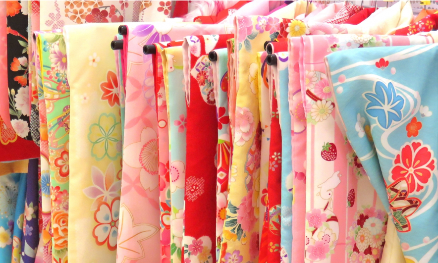 赤や青、ピンクなど様々な着物が掛けられている。