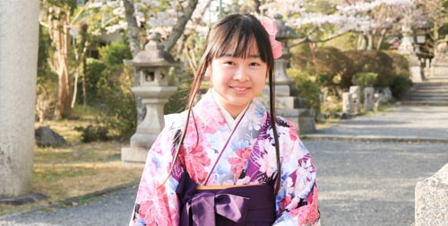 卒園・卒業式の袴姿で神社にたたずむ笑顔の女の子