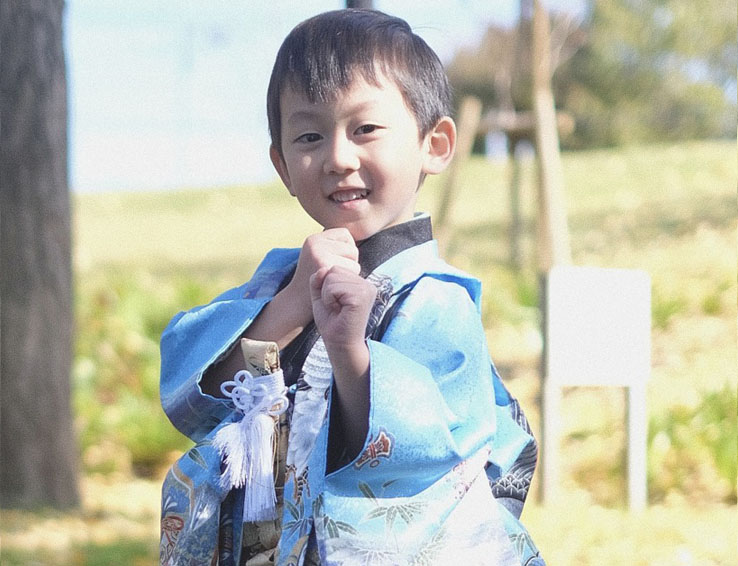番傘を肩に担ぐ着物姿の男児