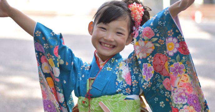 青い振袖で両手を広げる7歳の女の子
