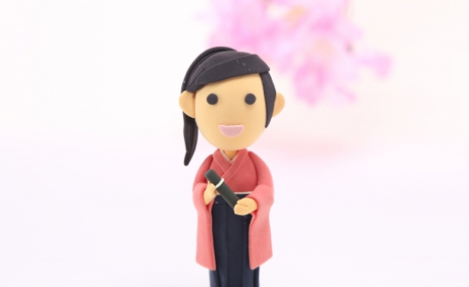 卒業証書を持った袴姿の粘土細工の少女