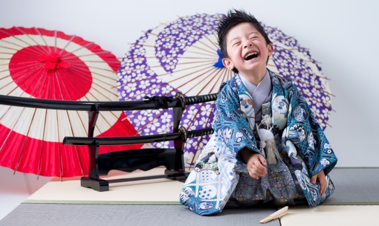 傘と日本刀をバックに青い着物着ている5歳男児